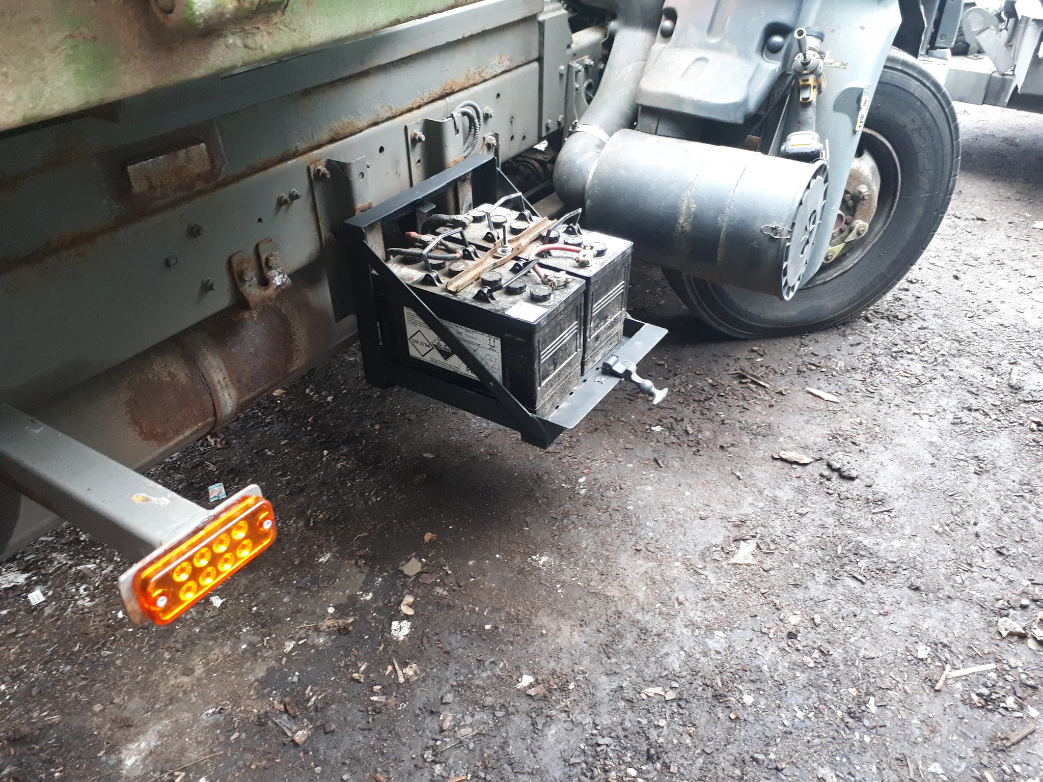 A metal battery frame mounted alongside a vehicle chassis
